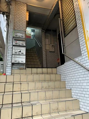 Brillio南浦和店が入るビルの入口階段とポスト